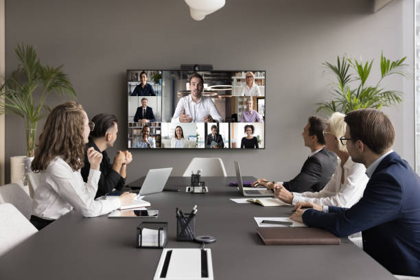Office employees and freelancers meeting on online video chat Business teem of office employees and freelancers meeting on online video chat, conference call. Coworkers sitting at negotiation table, looking at display with speaking distance colleagues conference call stock pictures, royalty-free photos & images