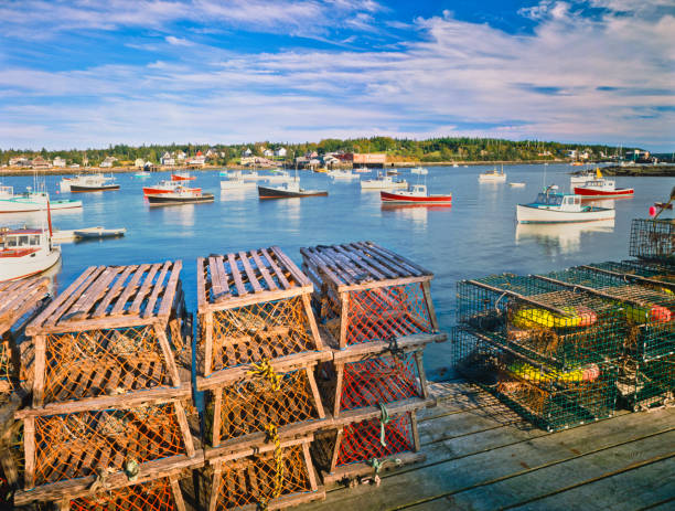 Maine Fishing Village Wooden Lobster Traps On A Dock With Fishing Boats In Bernard At Bass Harbor Maine fishing village stock pictures, royalty-free photos & images