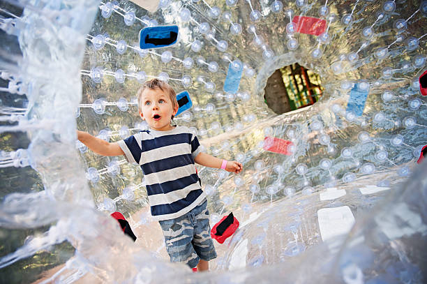 Inside a zorb sphere Little boy inside a zorb sphere in amusement park. zorb ball stock pictures, royalty-free photos & images