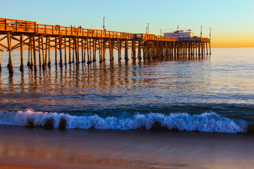Incoming tide reflects the sunset at Balboa Pier in Newport Beach, CA