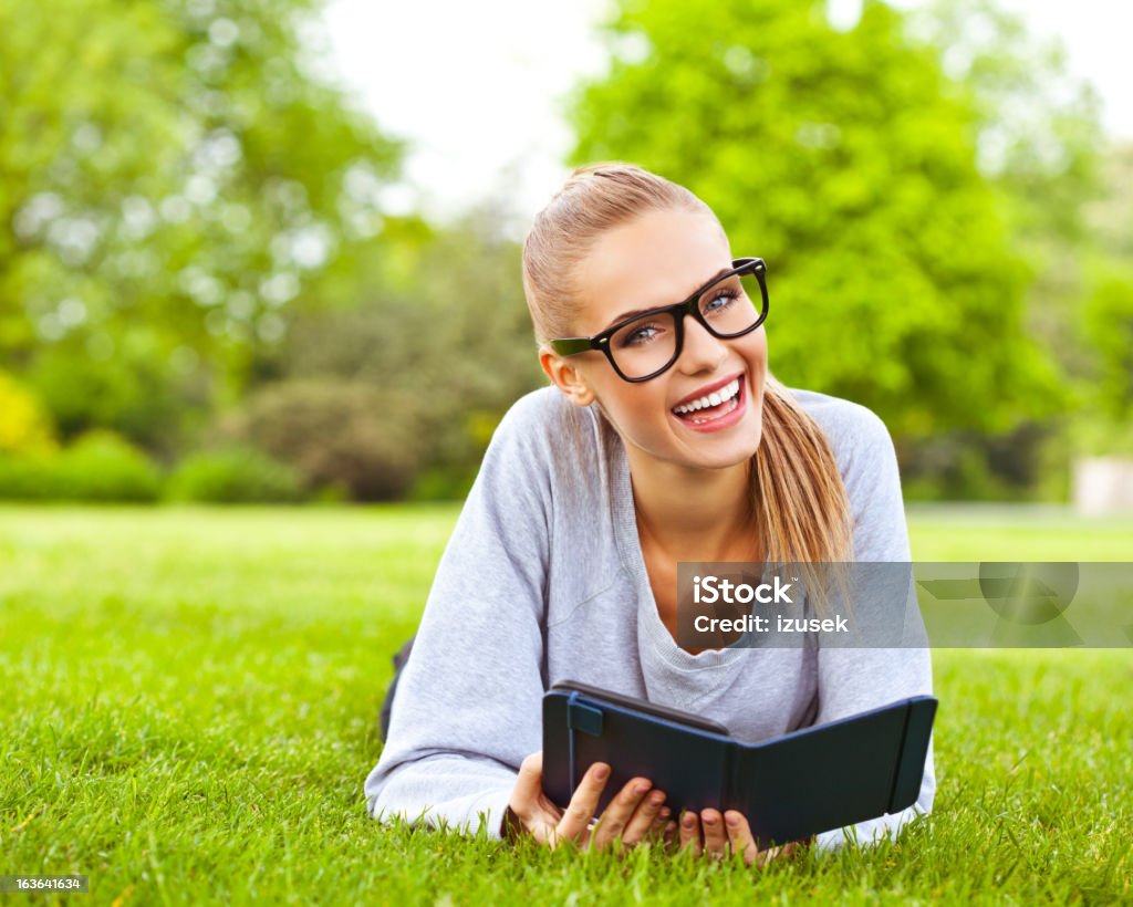 Mulher jovem feliz descanso um parque - Royalty-free Leitor de livros eletrónicos Foto de stock