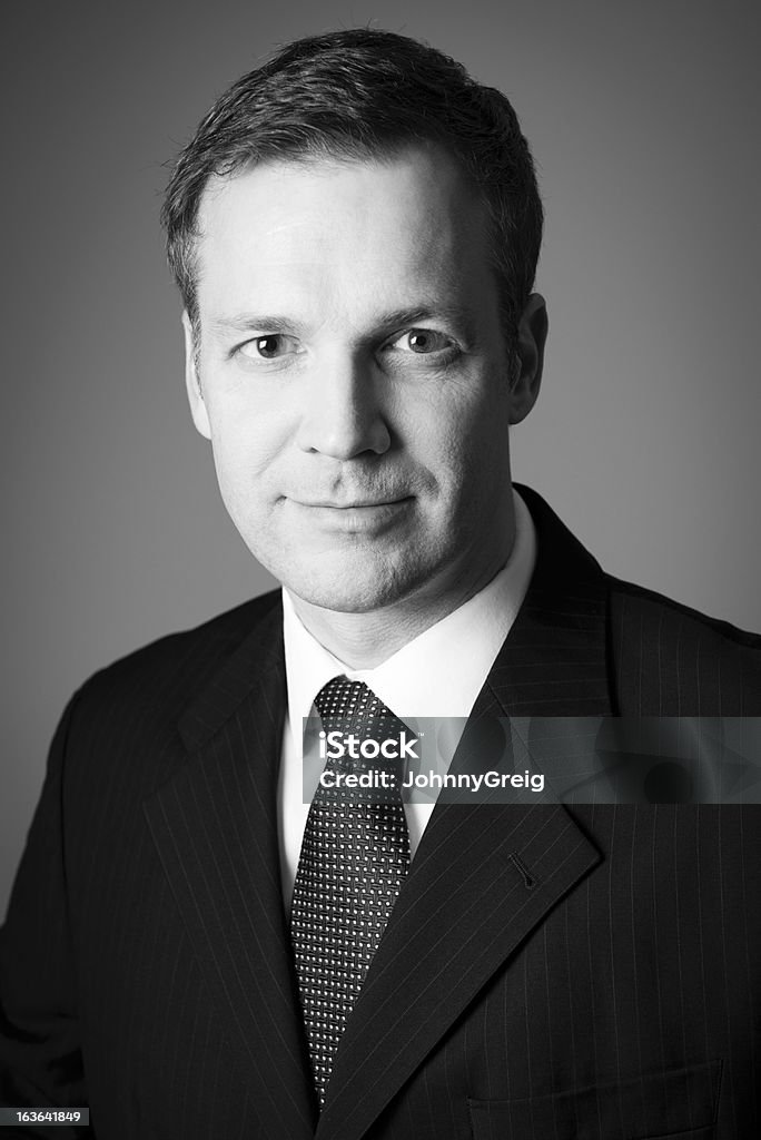 Businessman Headshot Portrait Headshot portrait of a mature Caucasian businessman in black and white monotone with nice strong shadow on face. Black And White Stock Photo