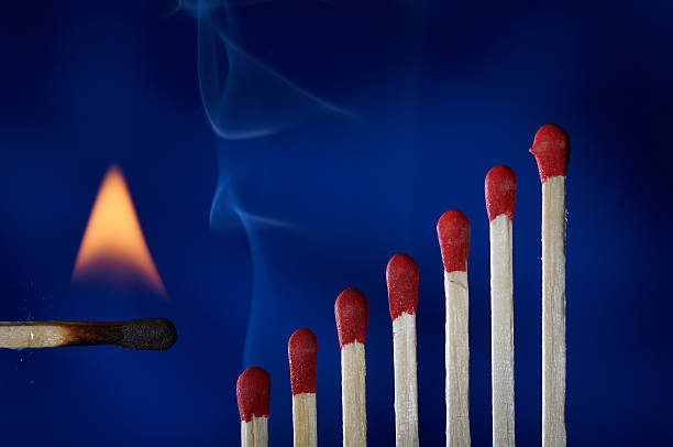 istock Wooden matches lined up like dominoes steps, in flames 163642030