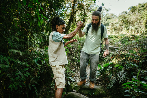 Tourist guide helping a mid adult man in the forest