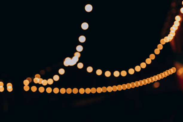 istock Decorative outdoor string lights at night time, Defocused Background, night city life backdrop, party time with Yellow bokeh balls 1636463734