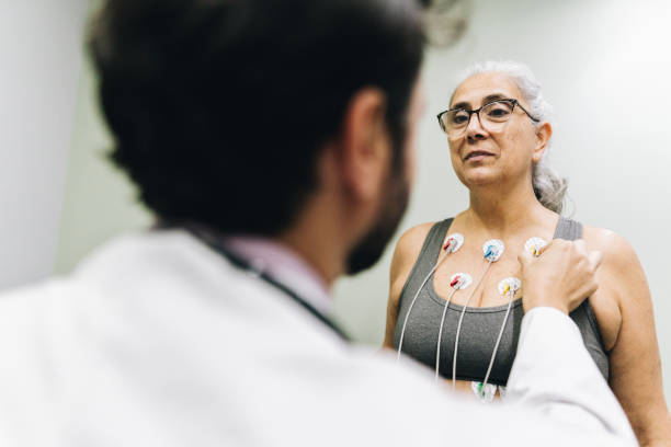 patientin im gespräch mit ihrem arzt während eines kardiopulmonalen belastungstests in einem krankenhaus - pulse trace arrhythmia electrode listening to heartbeat stock-fotos und bilder