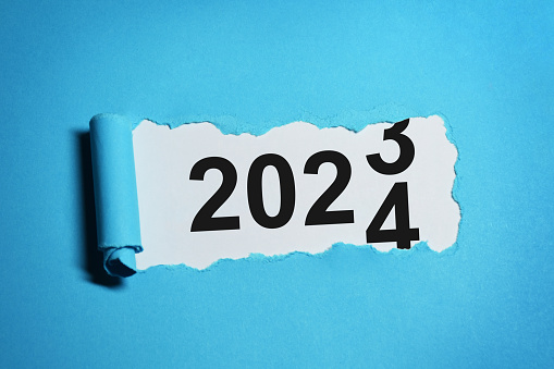 New year concept. The year 2023 changes to 2024. New year 2024 written inside torn paper