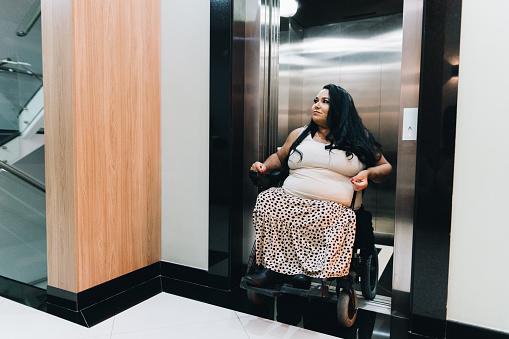 Wheelchair mature woman leaving elevator