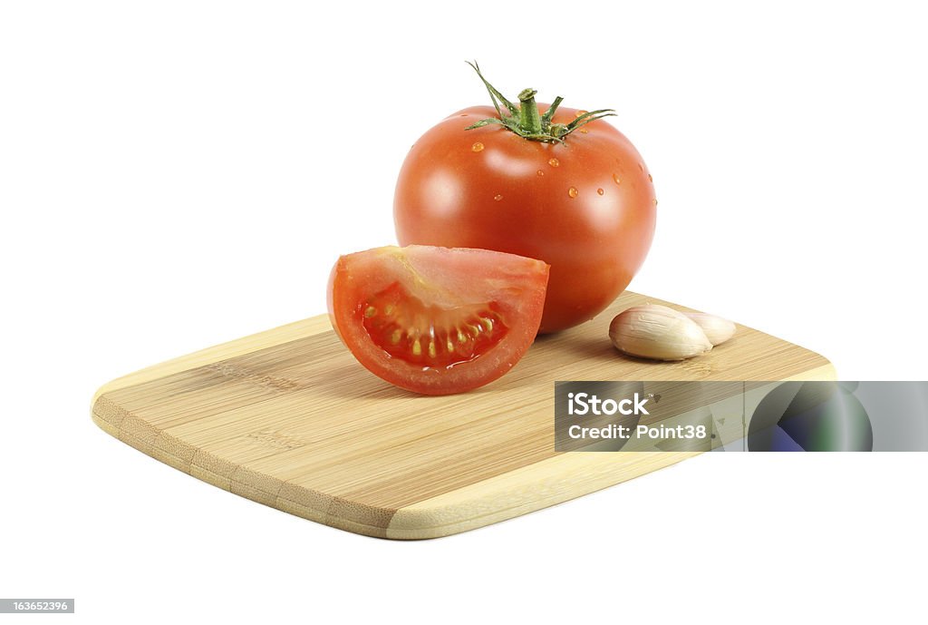 Czosnek i pomidory na Deska do krojenia - Zbiór zdjęć royalty-free (Artykuły spożywcze)