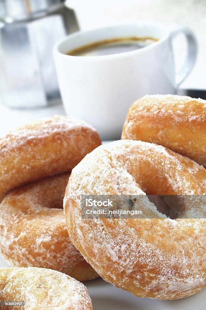 sugared donuts con taza de café en el fondo - Foto de stock de Alimento libre de derechos