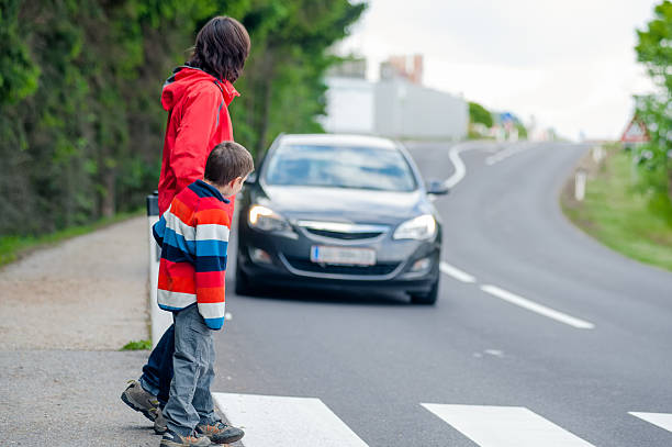 Car stopped for pedestrian Mother and son passing a street when a car coming crossing stock pictures, royalty-free photos & images