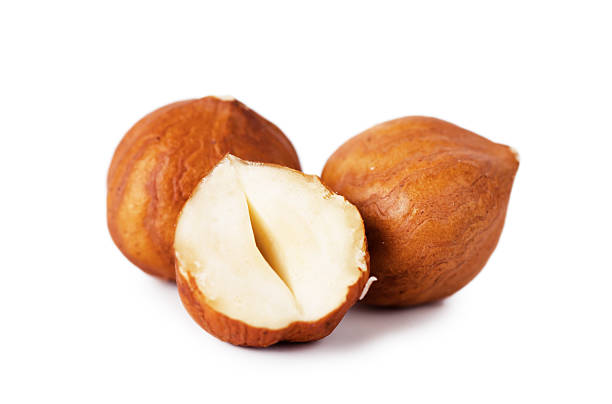 2 whole hazelnuts and 1 half hazelnut on a white background - fındık stok fotoğraflar ve resimler