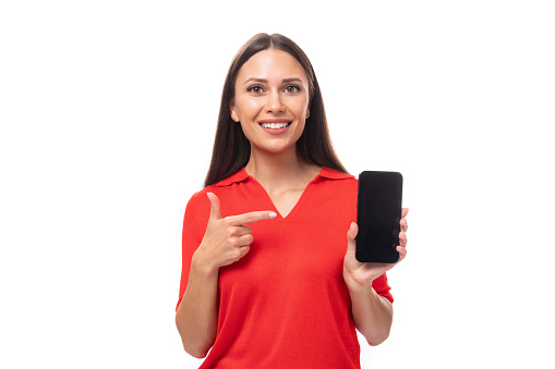 young caucasian brunette in red short sleeve shirt holding smartphone with screen mockup.