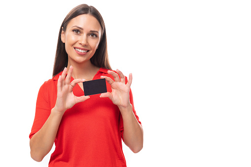 young attractive brunette woman in red stylish v-neck blouse holding credit card mockup.