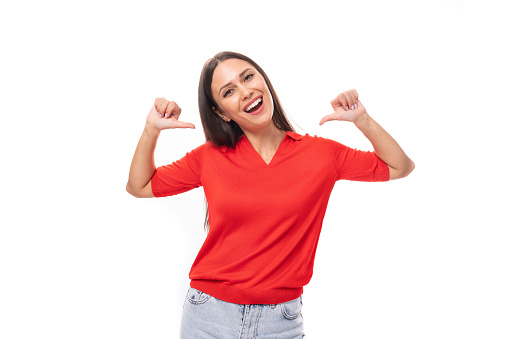 portrait of well-groomed brunette woman with straight hair in red t-shirt and jeans isolated studio background with copy space.