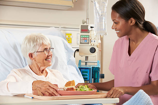 istock Nurse Serving Senior Female Patient Meal 163660071