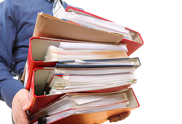 Male office worker carrying a stack of files Man holding stack of folders. Pile with old documents and bills. Isolated on white background tabs ring binder office isolated stock pictures, royalty-free photos & images