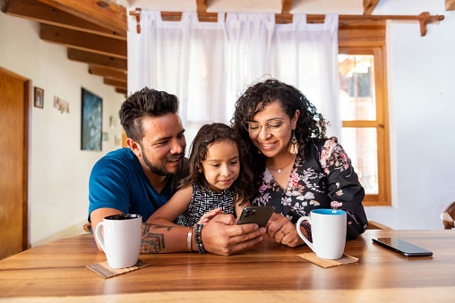 Family consuming content in cellphone