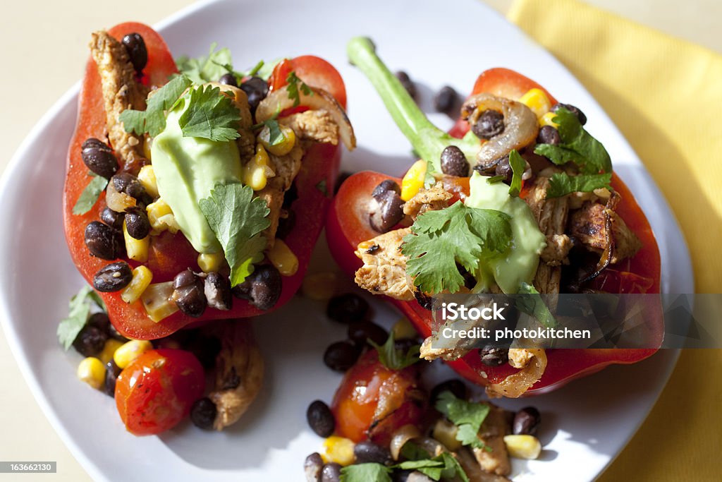 Mexican Stuffed Red Peppers Stuffed Red Peppers with cherry tomatoes, avocado, black beans, chicken, corn, cilantro and onions Black Bean Stock Photo
