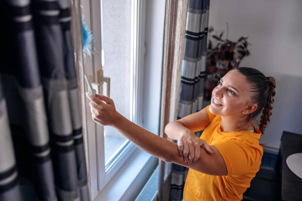 istock Young woman feeling pain while cleaning window at home 1636632589