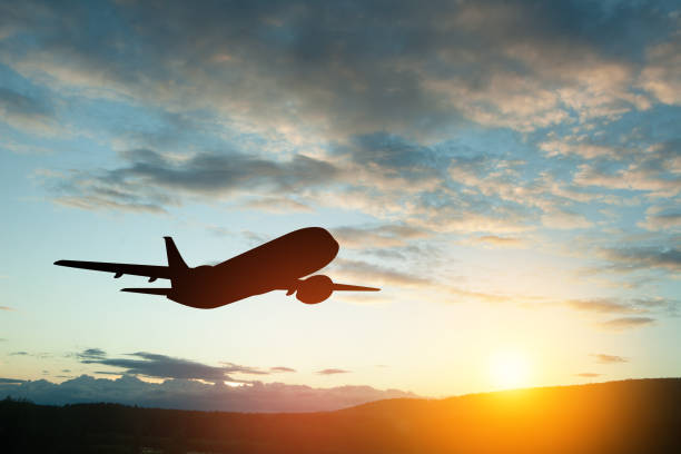 Airplane taking off at the sunset sky.