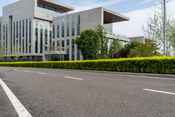 istock empty asphalt road in modern city with office buildings as background. 1636702699