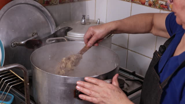 Close up of unrecognizable latin woman cooking onion and meat for filling chilean baked empanadas