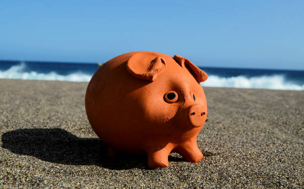 istock Coin Bank on Sand 1636737648