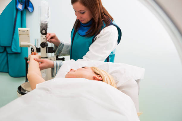 istock Young woman waiting for CAT scan with contrast,technician assisting 163674104