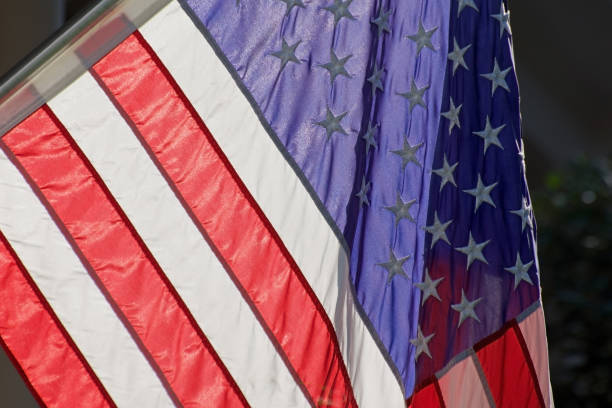 istock bright us american flag hanging cropped backlit with light 1636745919