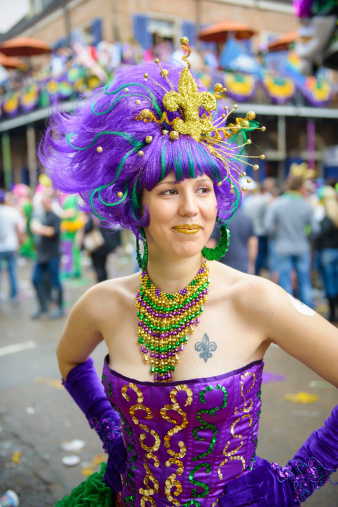A young woman dressed up on Fat Tuesday on Bourbon Street in New Orleans, LA. The tattoo on her chest is a fleur-de-lis, the symbol of New Orleans.
