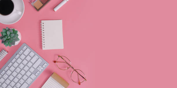 istock Directly above of office table desk with keyboard on pink background 1636752257