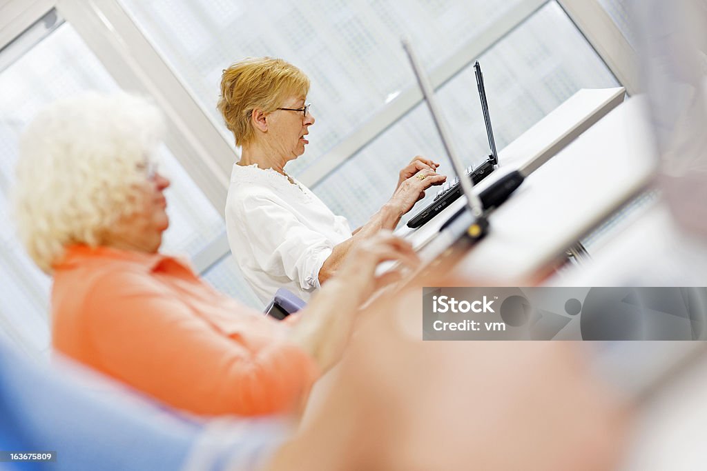 As mulheres idosas na oficina de computador usando Laptops - Foto de stock de 60-64 anos royalty-free