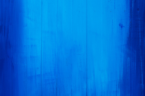 Old blue painted wooden board background. 