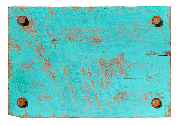 Turquoise grunge wood background with four rusty bolts.