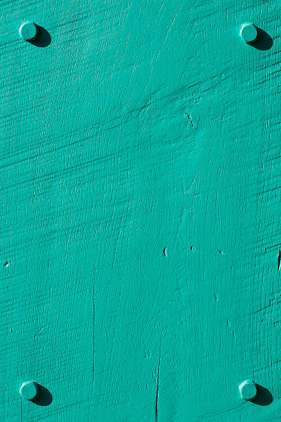 Turquoise grunge wood background with four bolts.