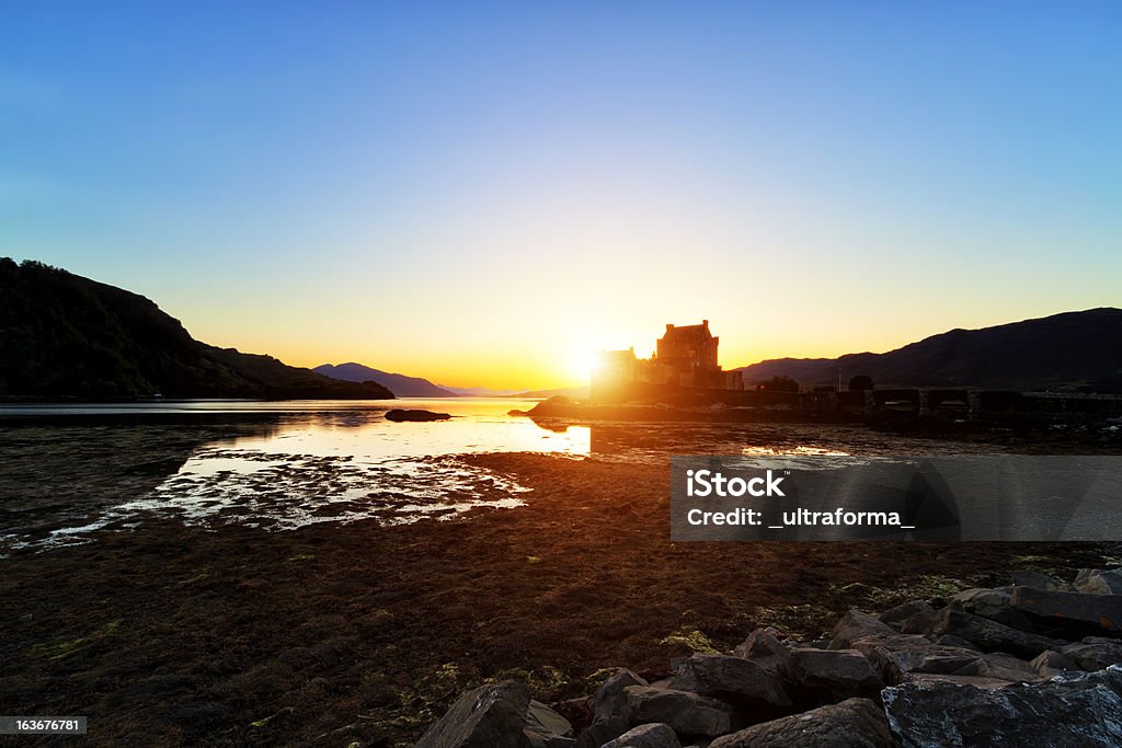 Eilean Donan Castle Sun setting behind Eilean Donan Castle in Scotland. Green Color Stock Photo