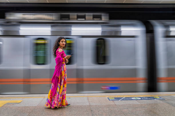 istock Indian girl using a mobile phone at metro station, India 1636769950