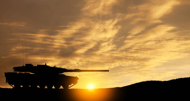 istock Silhouette of army tank at sunset sky background. 1636787618