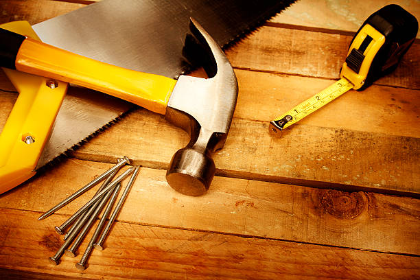 Work tools Hammer, nails, tape measure and saw on wood work tool nail wood construction stock pictures, royalty-free photos & images