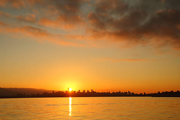 English Bay Sunrise, Vancouver, Canada Sunrise over downtown Vancouver from the south side of English Bay. British Columbia, Canada. beach english bay vancouver skyline stock pictures, royalty-free photos & images