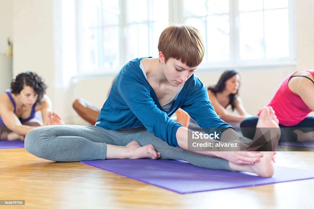 Estiramiento en clase de yoga - Foto de stock de Actividades recreativas libre de derechos