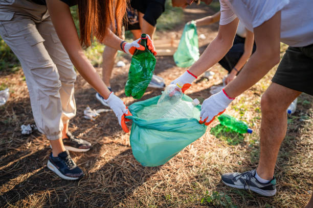 istock hands of unknown friends pick up waste garbage to clean forest 1636845583