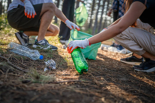 istock hands of unknown friends pick up waste garbage to clean forest 1636846608