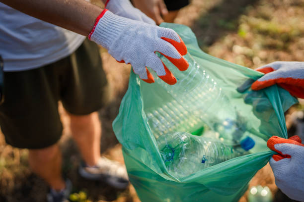 istock hands of unknown friends pick up waste garbage to clean forest 1636847472