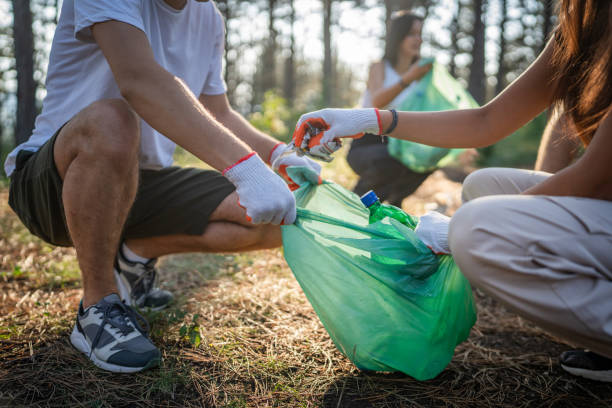 istock hands of unknown friends pick up waste garbage to clean forest 1636849064