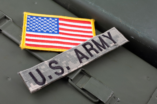US ARMY Branch Tape with national US flag patch on green ammo can background