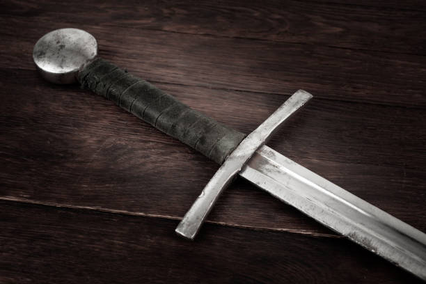 Medieval sword on wooden backgrond. Medieval vintage sword on wooden backgrond. excalibur stock pictures, royalty-free photos & images