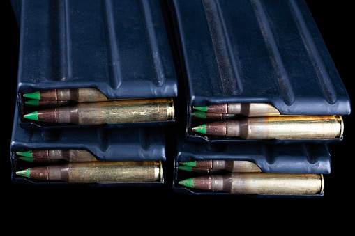 5.56mm ammunition in magazines on black background