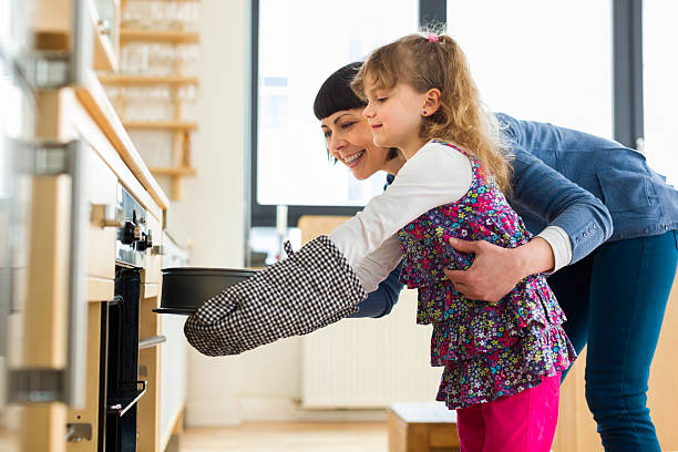 mãe e filha assar um bolo - family germany baking berlin germany - fotografias e filmes do acervo